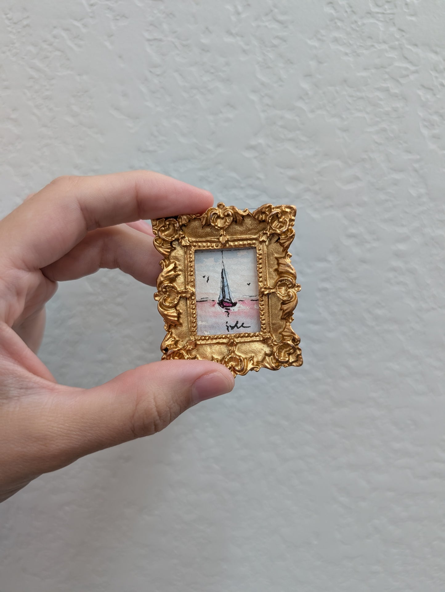 a person holding a small picture frame in their hand