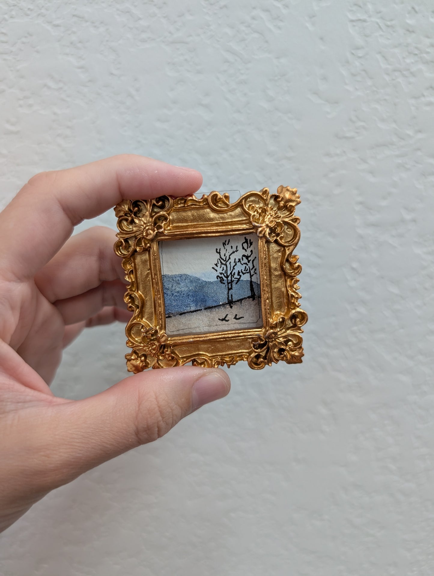a person holding a small picture in their hand
