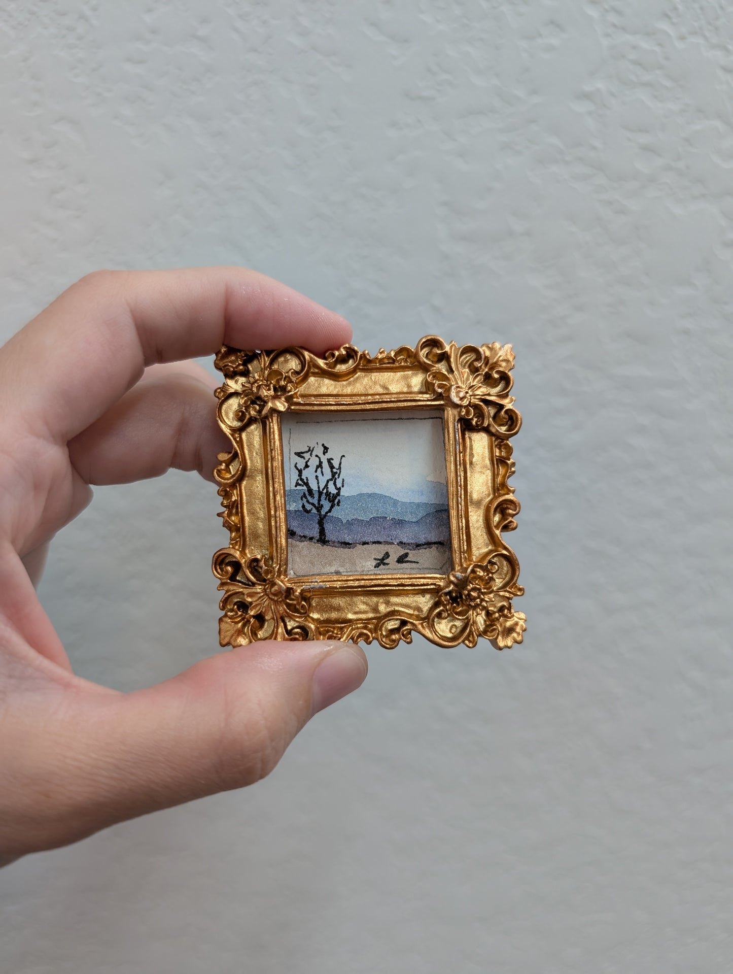 a person holding a small picture in their hand