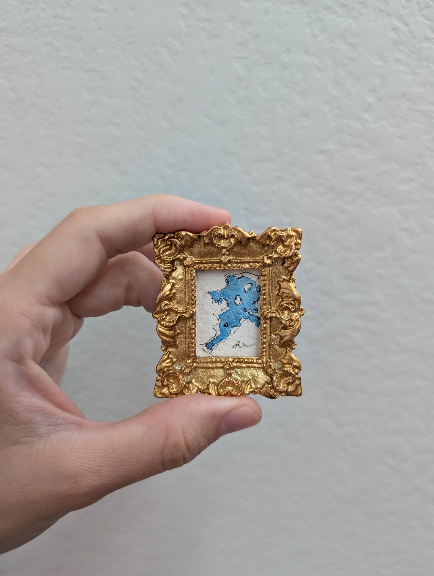 a person holding a small picture frame with a picture of a dog in it