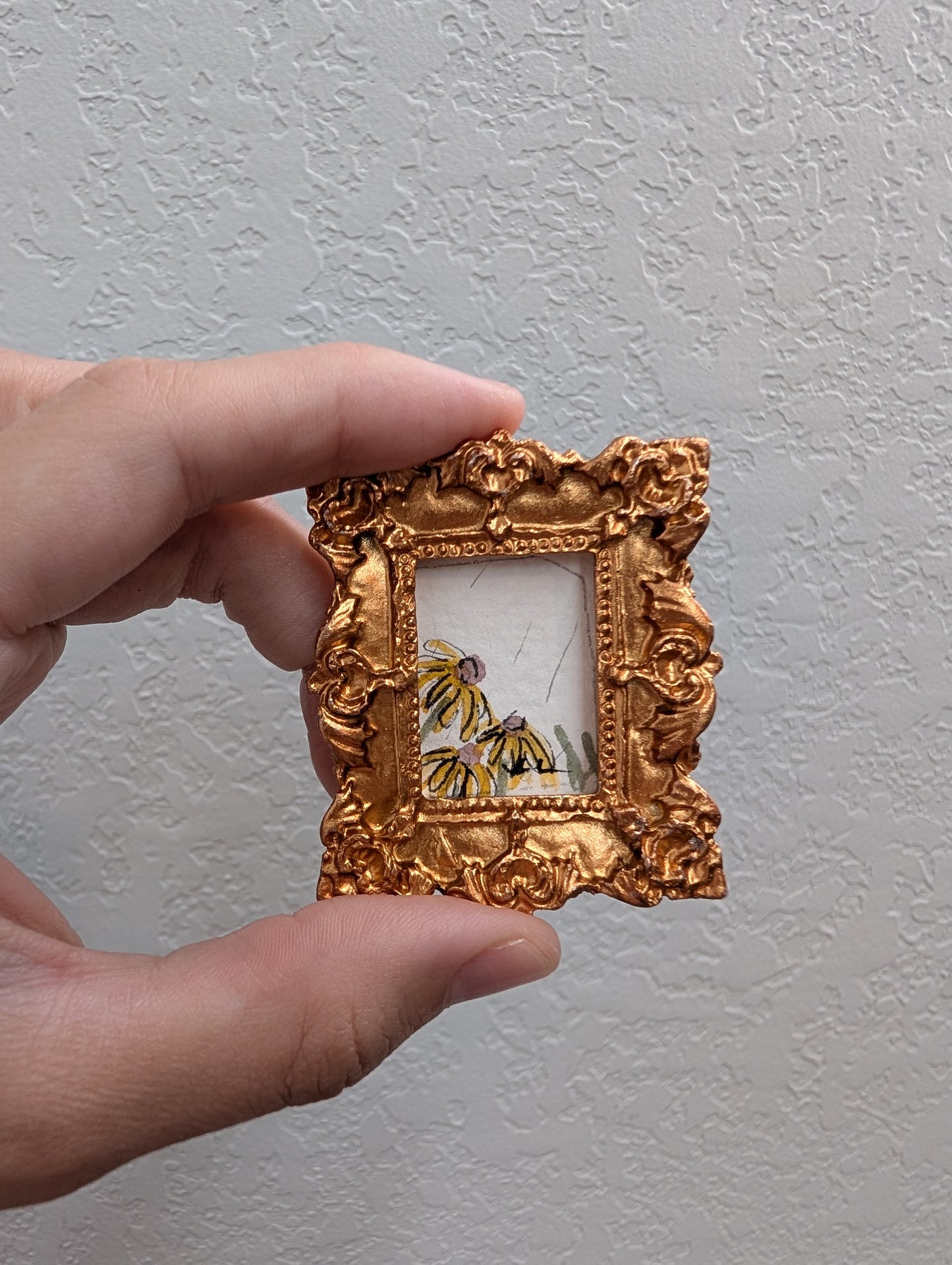 a person holding a small picture frame with a butterfly on it