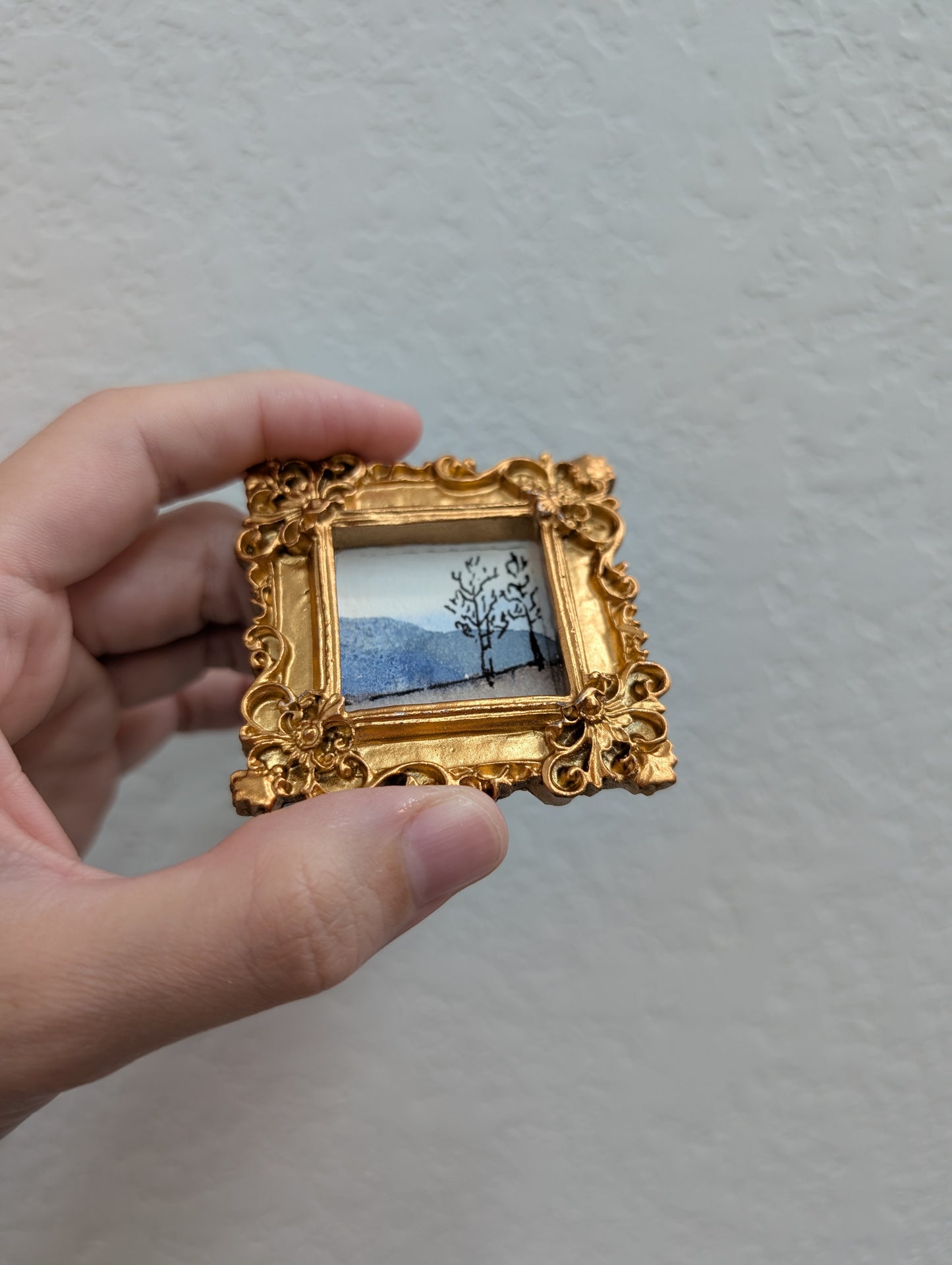 a person holding a small picture in their hand