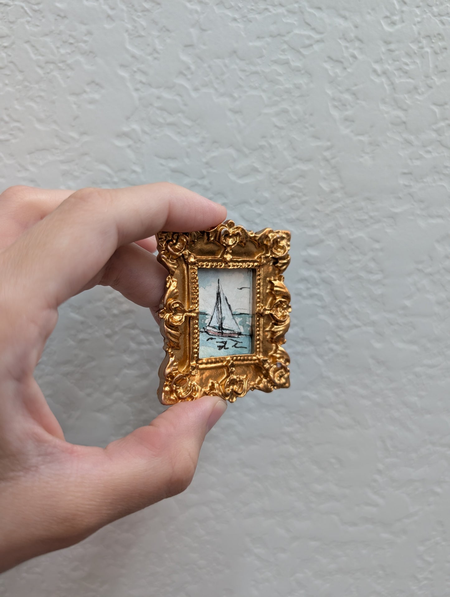 a person holding a small picture frame in their hand