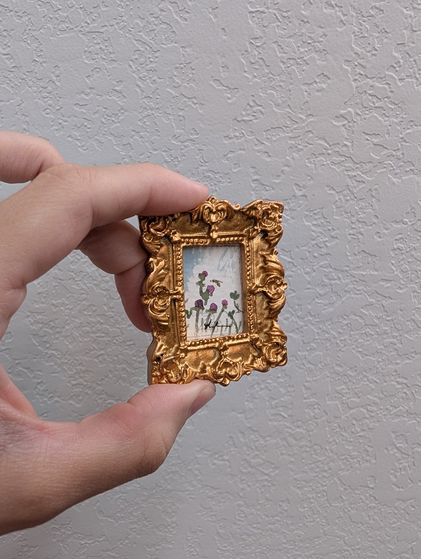 a person holding a small picture frame with flowers on it