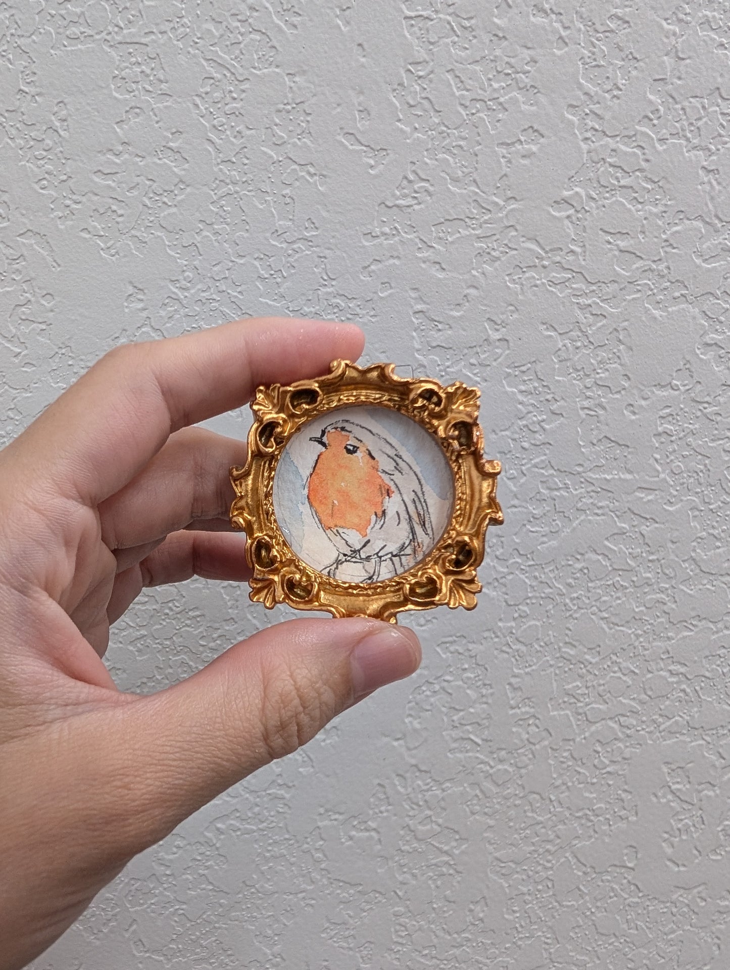 a person holding a miniature picture in their hand