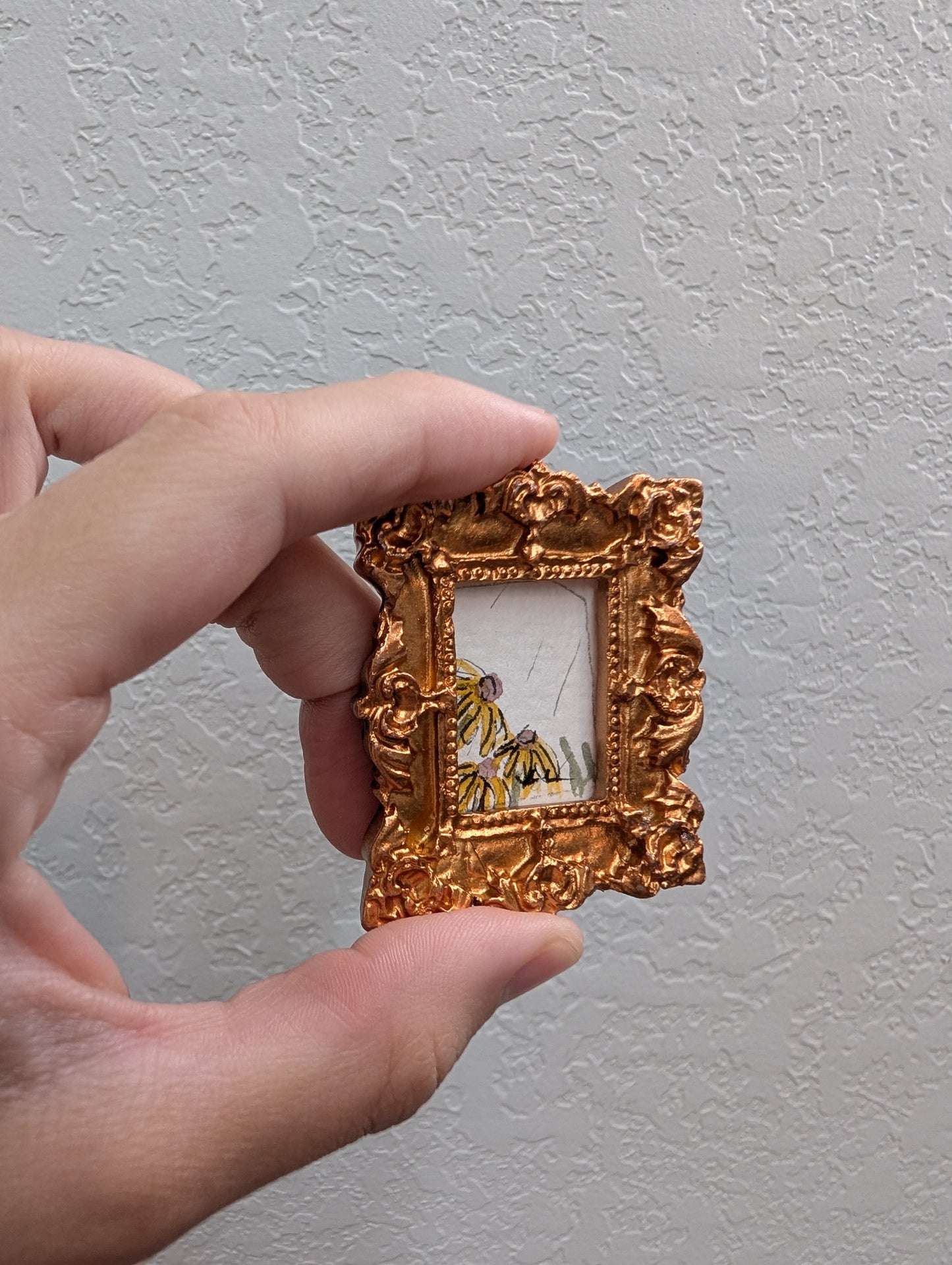 a person holding a small gold frame with a picture of a tiger