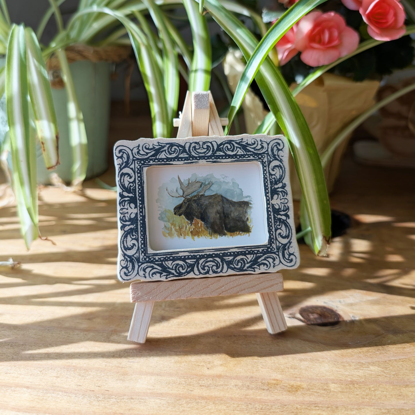 a picture of a moose on a wooden easel