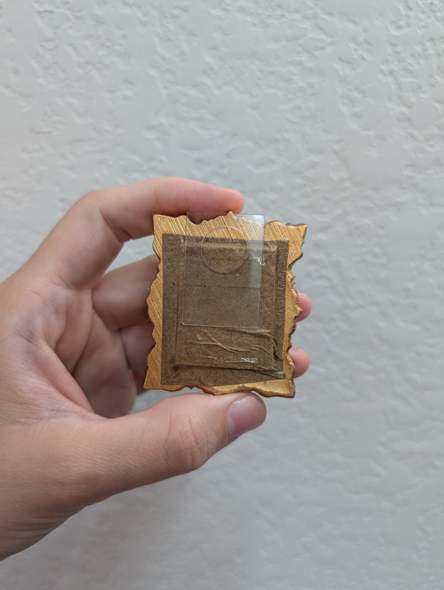 a person holding a small square object in their hand