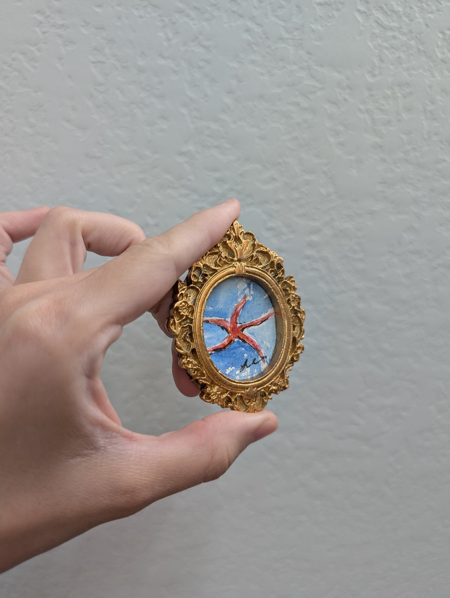 a person holding a miniature clock in their hand
