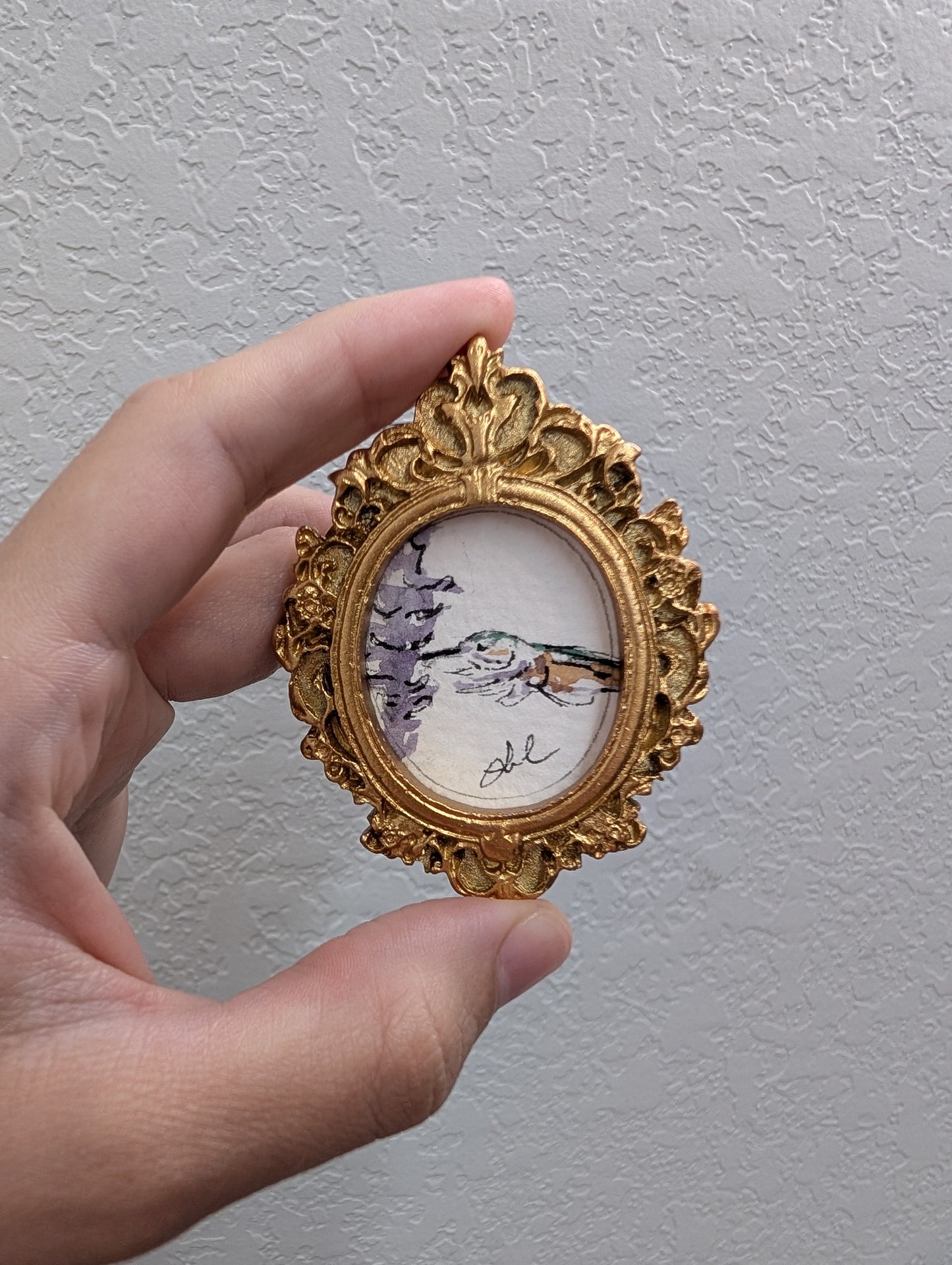 a person holding a small picture frame in their hand