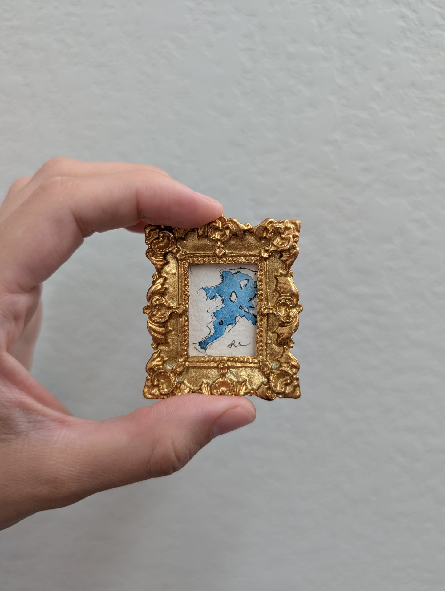a person holding up a small picture frame
