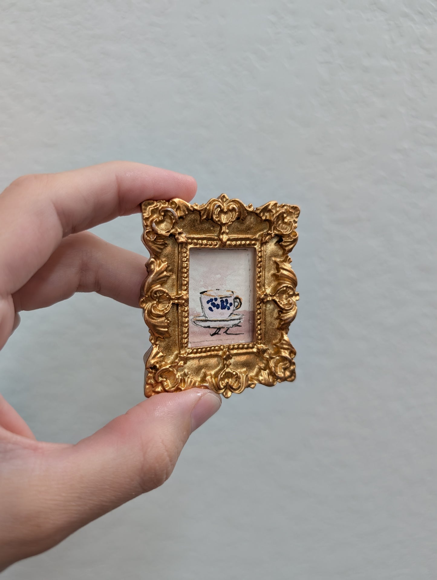 a person holding a small picture frame in their hand