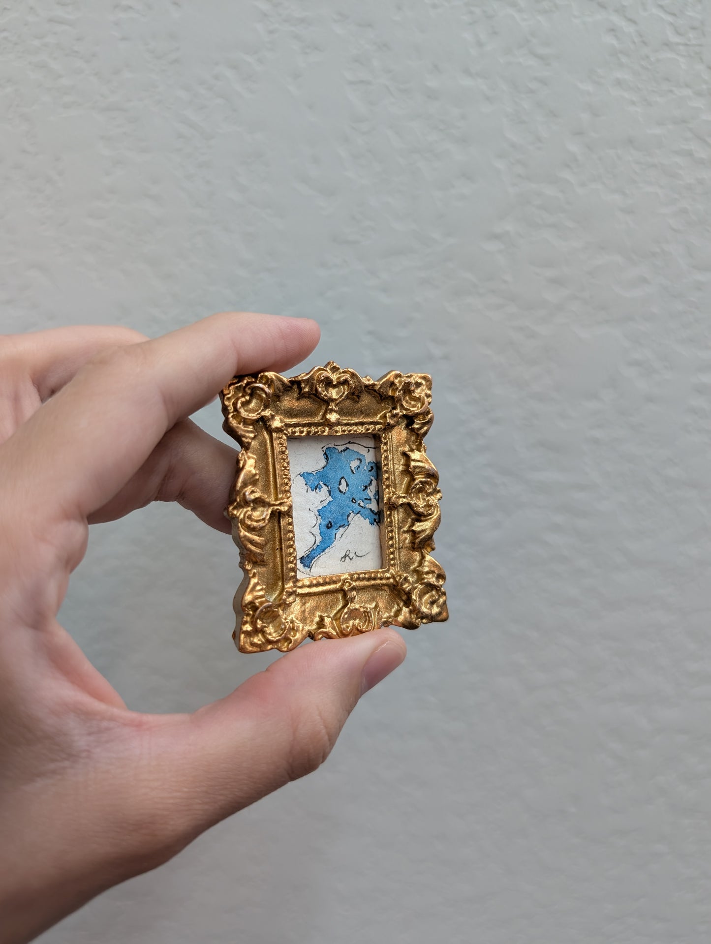 a person holding a small picture frame in their hand