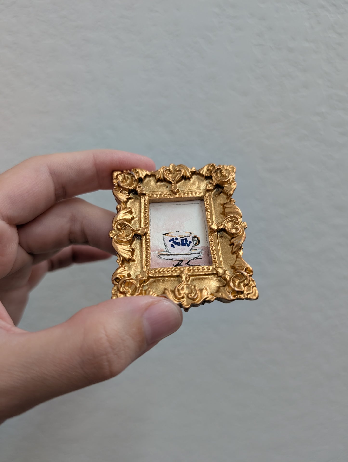 a person holding a small gold picture frame