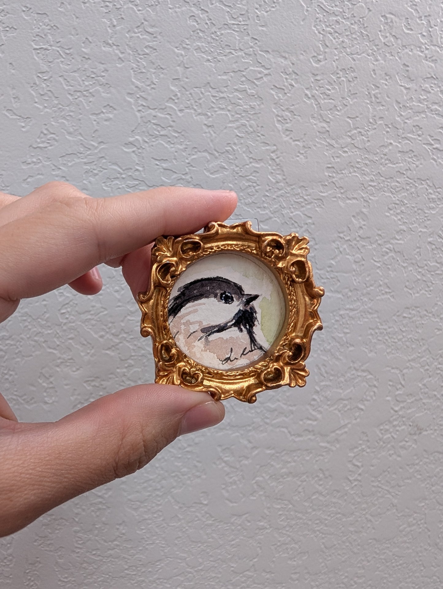 a person holding a small picture of a bird