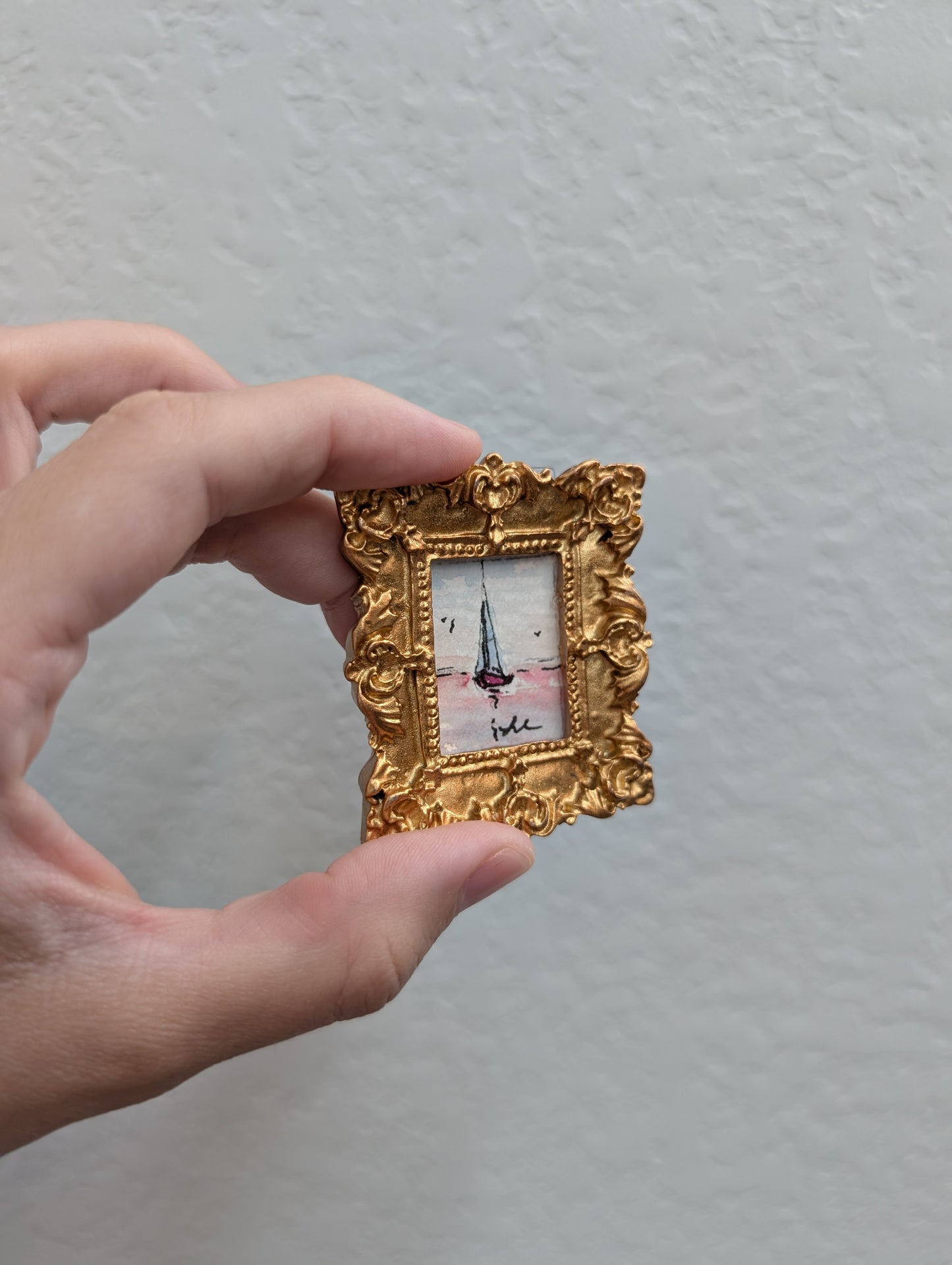 a person holding a small picture frame in their hand