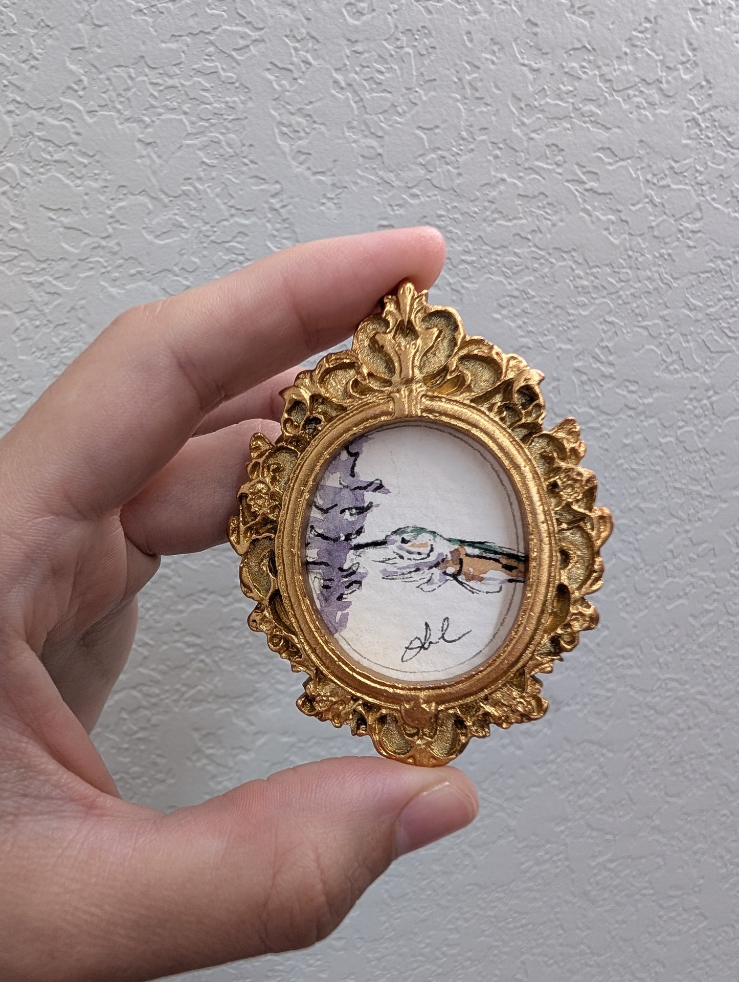 a person holding a miniature picture in their hand