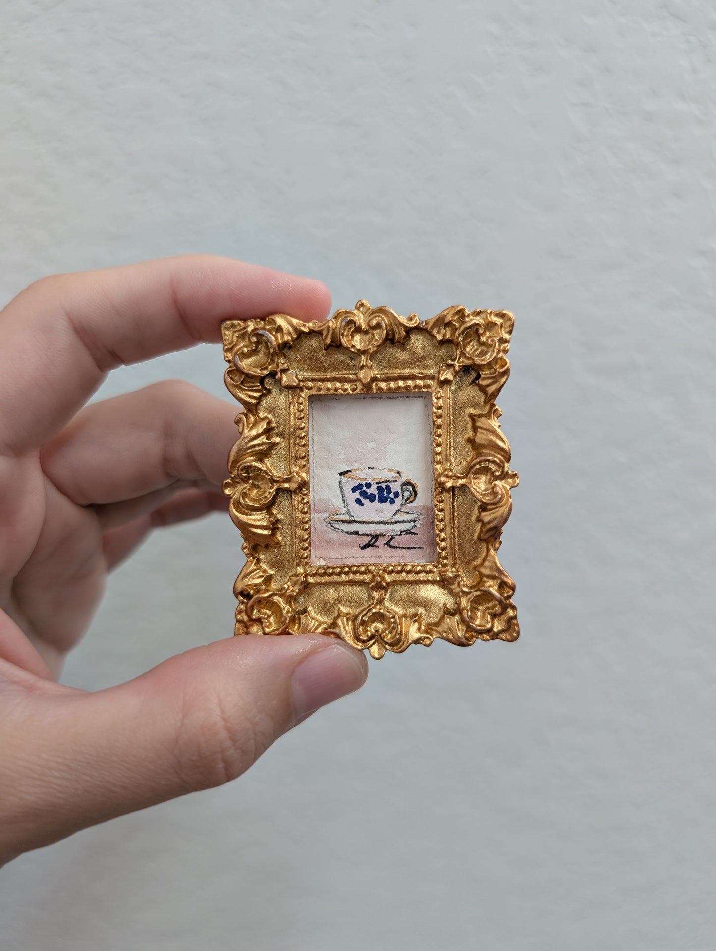 a person holding up a small picture frame