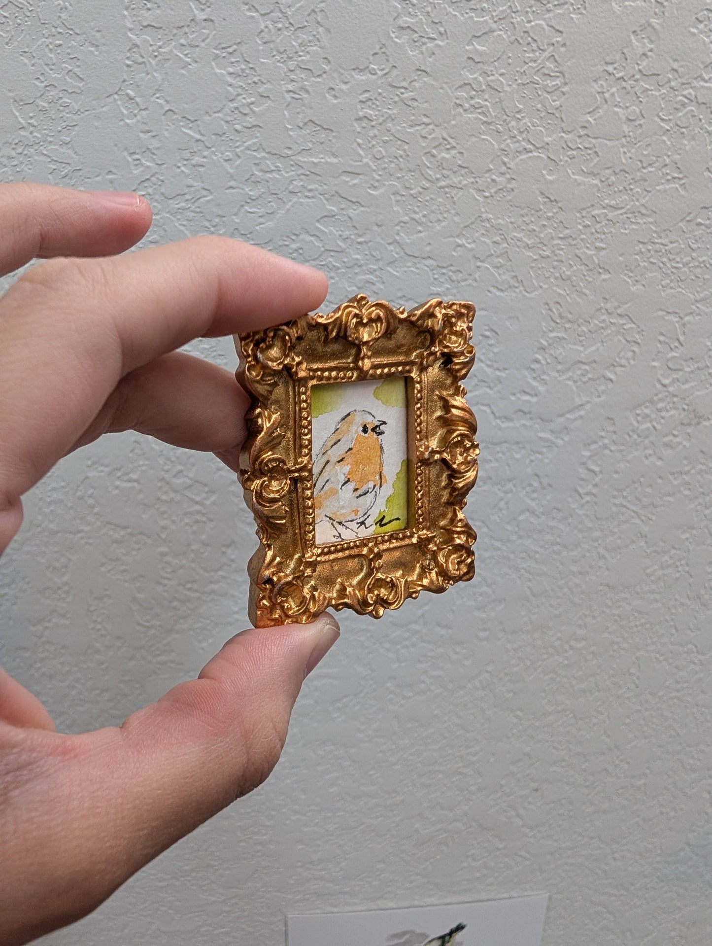 a person holding a small picture frame in their hand