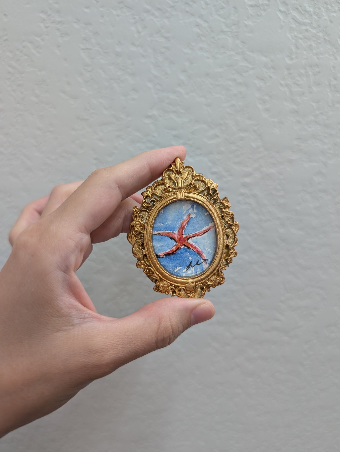 a person holding a small picture in their hand