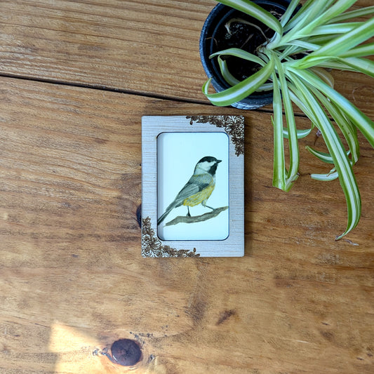 a picture of a bird sitting on top of a wooden table