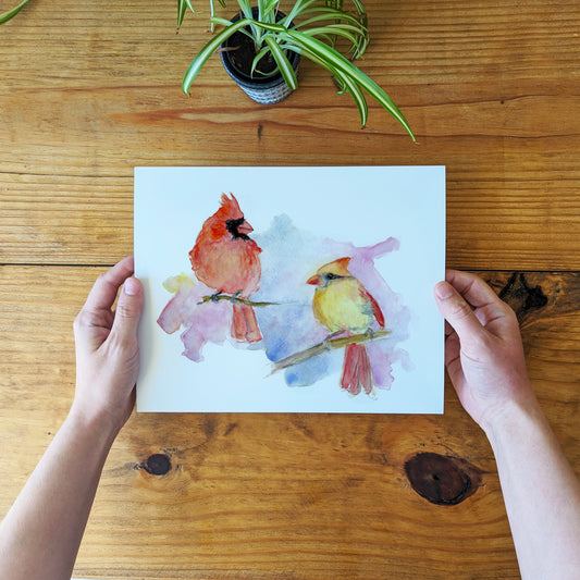 a person holding a card with two birds on it