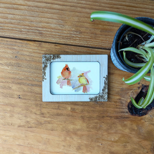 a picture of two birds sitting on top of a wooden table