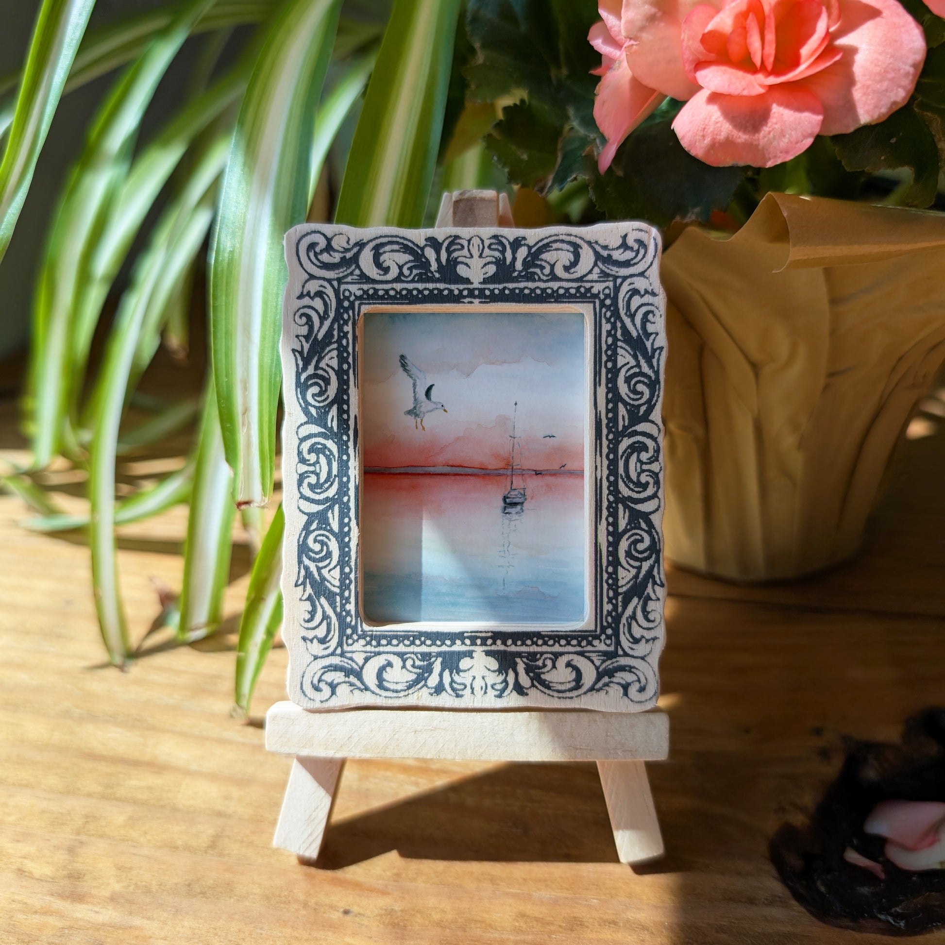 a picture frame sitting on a table next to a potted plant