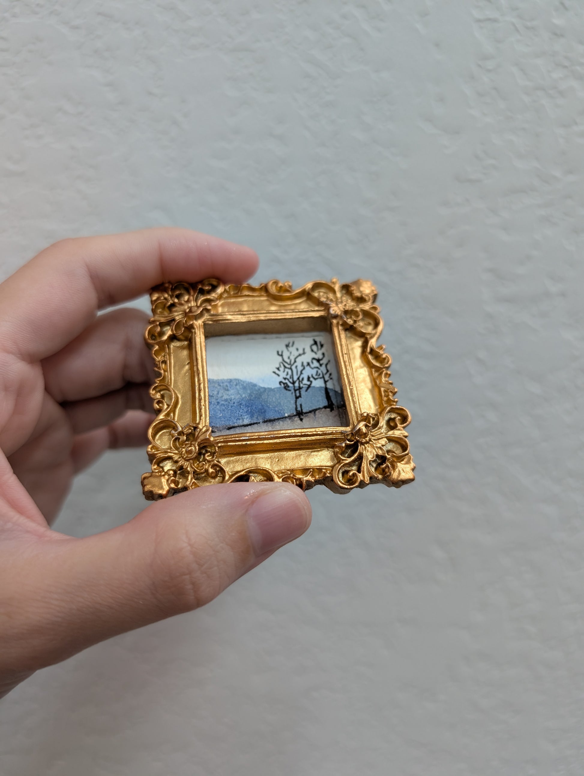 a person holding a small picture in their hand