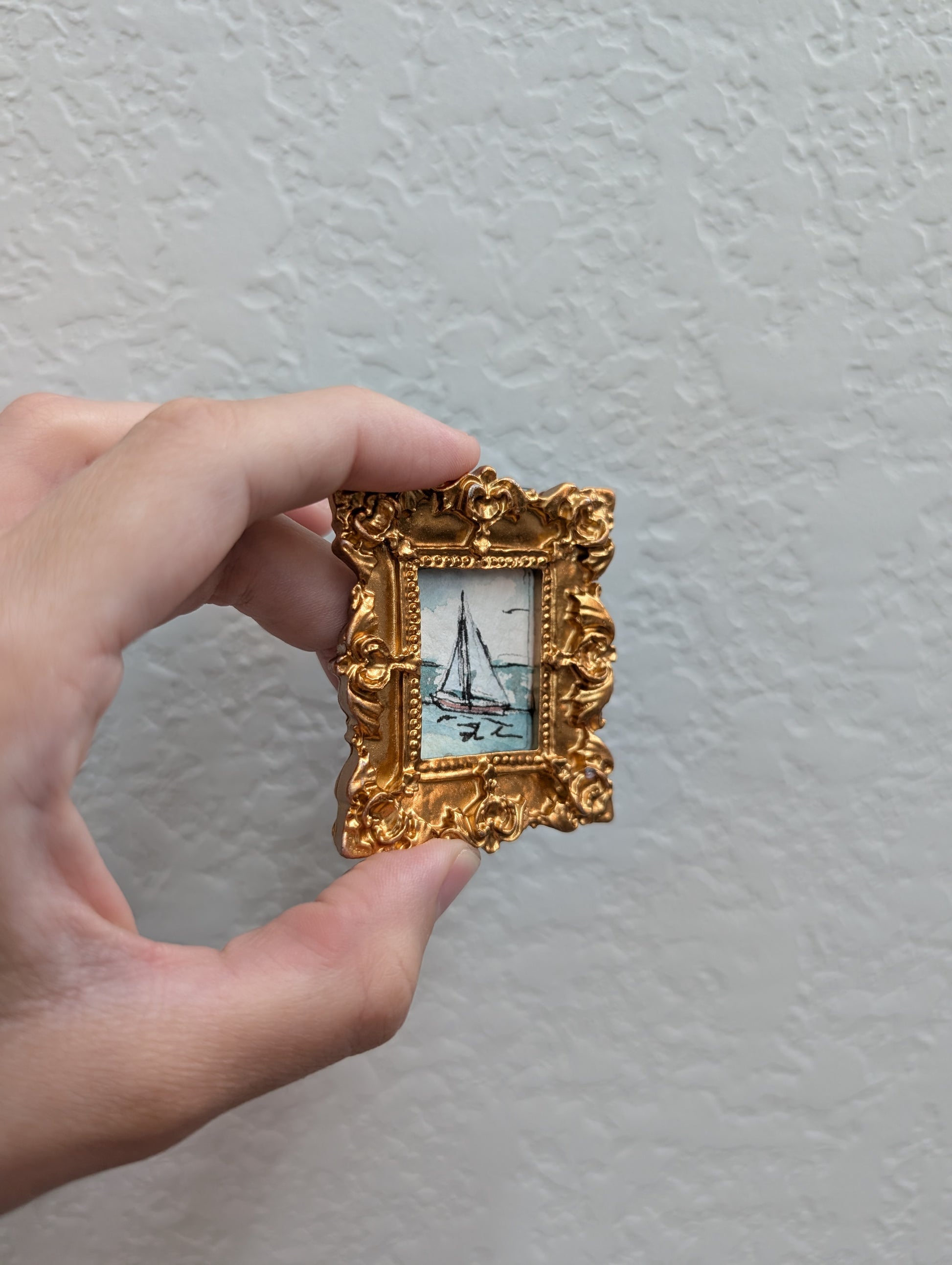 a person holding a small picture frame in their hand