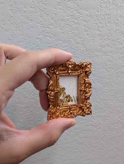 a person holding a small gold frame with a picture of a tiger