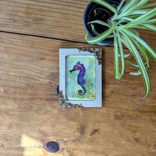 a picture of a sea horse on a wooden table