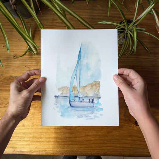 a person holding a card with a sailboat on it