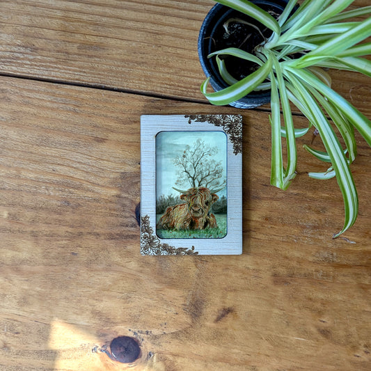 a small picture frame sitting on top of a wooden table