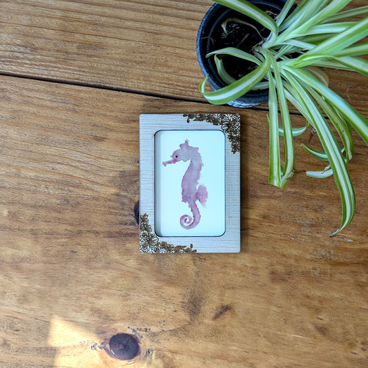 a picture of a pink sea horse on a wooden table