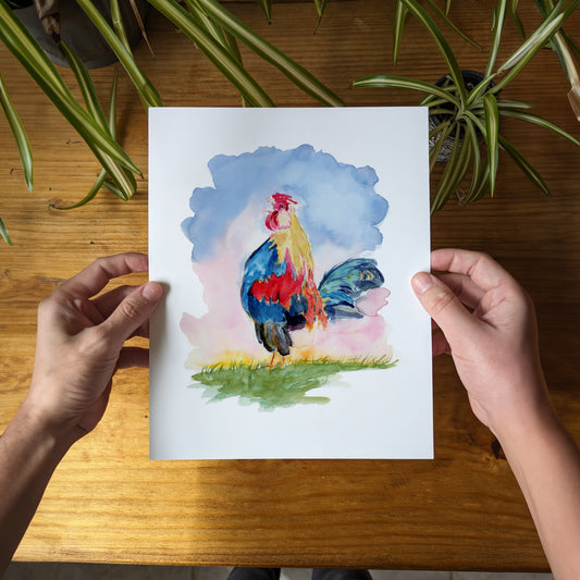 a person holding a card with a painting of a rooster