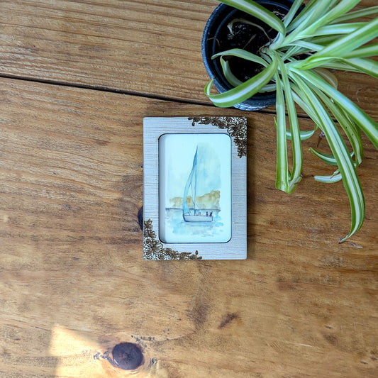 a picture of a sailboat on a wooden table