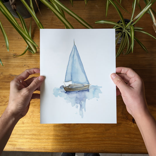 a person holding a piece of paper with a boat on it