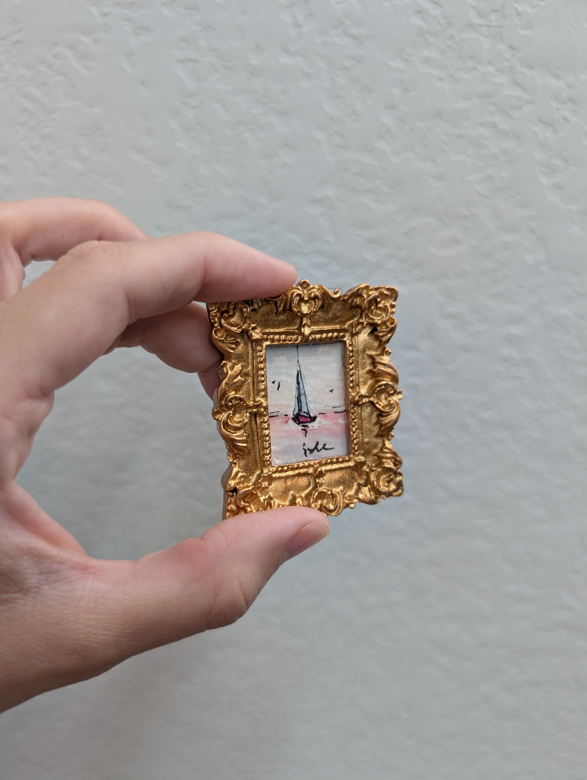 a person holding a small picture frame in their hand
