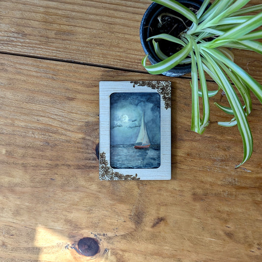 a picture of a sailboat on a wooden table